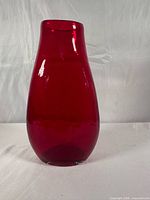 Full view of ruby red glass vase standing upright