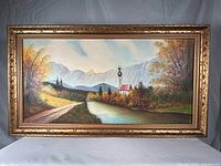 Full view of framed oil painting showing landscape scene and gilt frame