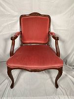 Front view of carved wood armchair with pink upholstery