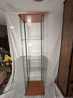 Full front view of one cabinet showing glass panels, wood top/base