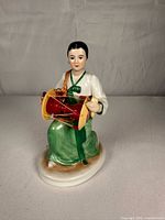 Front view of figurine holding janggu drum