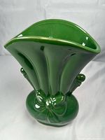 Oblique view showing fluted fan opening, handles, bow motif, glaze sheen