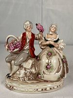 Front view of figurine showing couple, grape basket and base detailing
