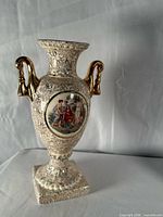 Front view showing gilt handles, classical scene medallion, and floral transfer pattern