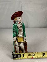 Front view of figurine with measuring tape showing height just under 4 inches
