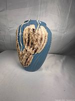 Full view of blue ribbed vase with applied leaves