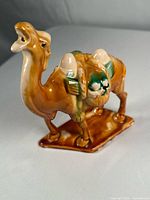 Camel figurine side view showing glaze, saddle detail, base