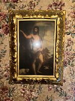 Frontal view of framed artwork showing image and ornate gold frame