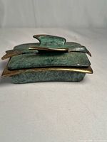 Closed trinket box side profile showing verdigris patina and brass edge detail