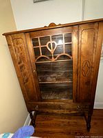 front view showing glass door, lattice, drawer and legs