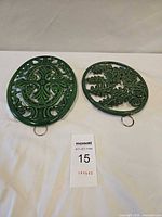 Two green cast iron trivets overall view