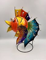 Side view of colorful metal puffer fish sculpture on stand