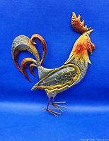 Front view of colourful painted tin rooster wall decor