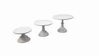 Three different-sized white metal cake stands side by side