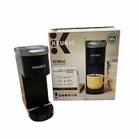 Keurig K-Mini coffee maker standing beside its retail box