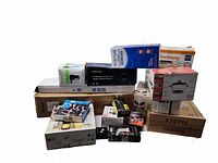 Overview of stacked retail and cardboard boxes showing printer, Harmony, Wemo and other packaging