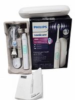 All components displayed: handle, brush head, charger, travel case, manual, retail box