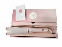 Curling iron laid in open original box with booklet visible