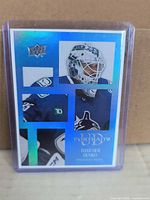 Front view of Upper Deck UD Portraits Thatcher Demko holographic hockey card inside clear top loader