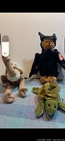 Group shot of ostrich, bear in bat costume and turtle plush
