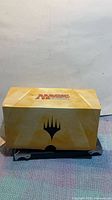 Exterior of yellow Magic: The Gathering branded cardboard box