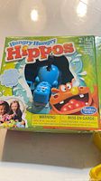 Front of Hungry Hungry Hippos box featuring blue hippo figure