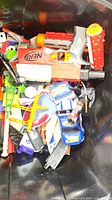 Overview of black bin with Nerf blaster, vehicles, track pieces