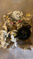 bin containing multiple resin angel figurines, black teapot, ceramics