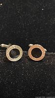 Front view of both cufflinks showing black centres and Greek key border