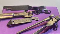 Group of five vintage metal can openers on purple surface