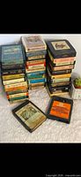 Two vertical stacks of 8-track tapes and two loose tapes showing quantity and variety