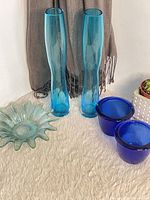 Group shot of two tall aqua vases, starburst bowl, two cobalt bowls