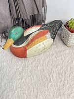 full view of ceramic mallard decoy from left side on rug