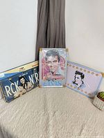 Three Elvis Presley tin license plate style signs on table