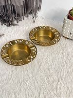 pair of brass ashtrays displayed side by side