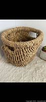 Front angled view of woven wicker basket showing side handle opening