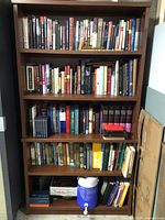 Full view of brown veneer bookshelf with five shelves