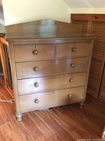 Front view of chest showing drawers, backsplash and turned feet