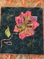 Square quilted wall hanging with flower and dragonflies on dark background