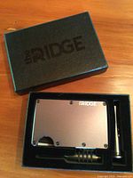 Wallet, tool, and strap in foam insert within original Ridge box