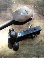 Triple ball hitch mount and folding shovel on wood surface