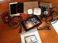 Overview showing all electronics including GPS, iPhones, trackpad, mouse, chargers, hub, EarPods, KeySmart