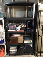 Full view of black plastic shelving unit with contents displayed for scale