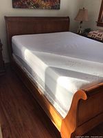 Full view of queen sleigh bed frame with mattress in place