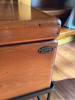 Close-up of wood grain and 45 Parallel Collection badge on table corner