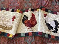 Overall view of three quilted rooster fabric art pieces showing design and borders