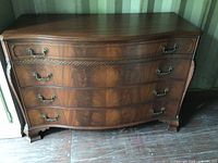 Front view of bow front walnut buffet-sideboard showing four drawers and brass hardware