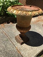 Full view of cast iron garden urn showing overall design and patina