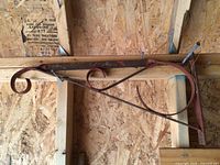 Full view of metal sign bracket mounted on stud showing overall design