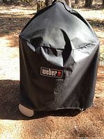 Grill covered with black Weber cover